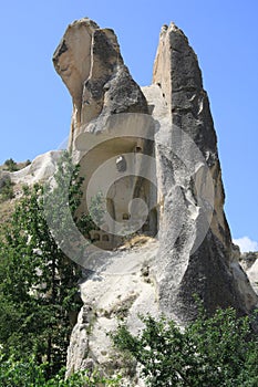 Pigeon lofts carved into the fairy chimneys against a bright blue sky- Cappadocia photo